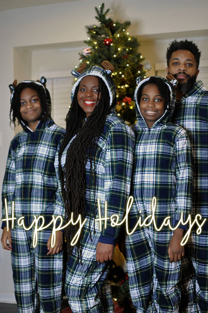 Black family in matching pajamas at Christmas